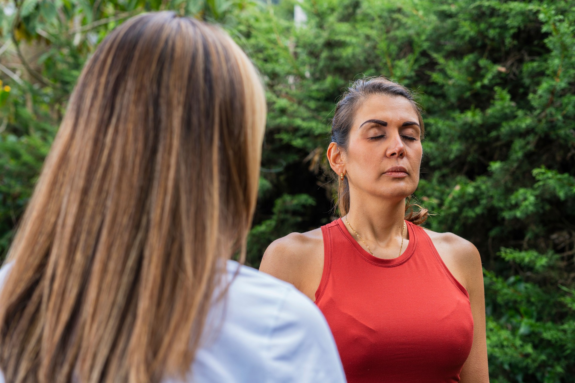 Latina woman yoga teacher teaches her patient Latina woman who attends her office to know how to control her breathing